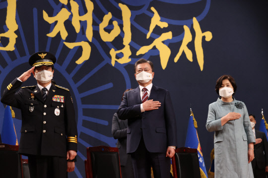 문재인 대통령과 부인 김정숙 여사가 12일 오후 충남 아산시 경찰대학에서 열린 신임 경찰 경위·경감 임용식에 참석, 국기에 경례하고 있다.  연합뉴스